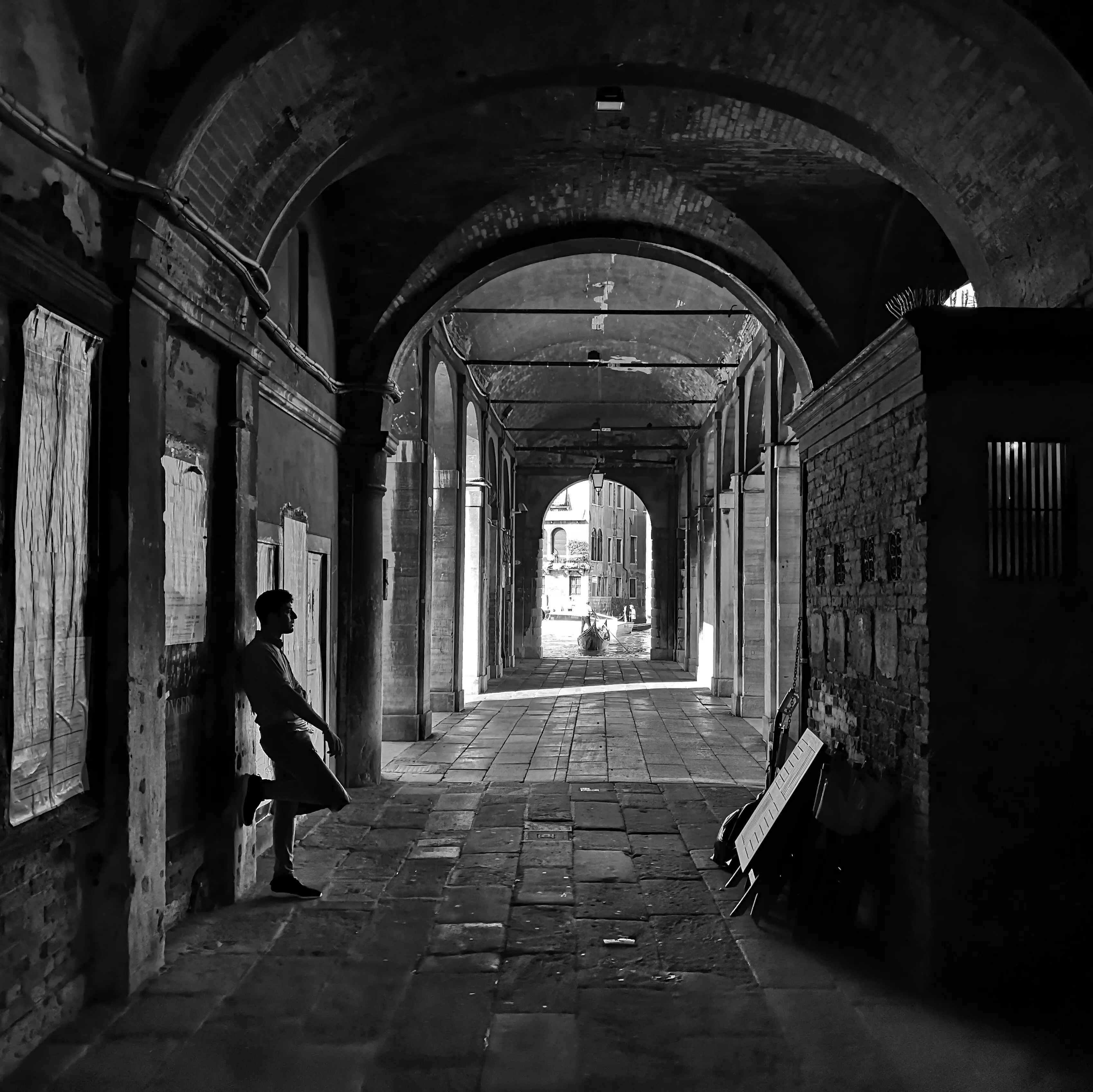 Seitenansicht eines Mannes, der in einem Gebäudeflur steht.